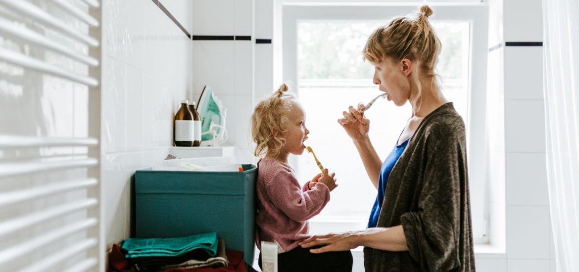 Mom brushing teeth with child