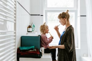 Mom brushing teeth with child